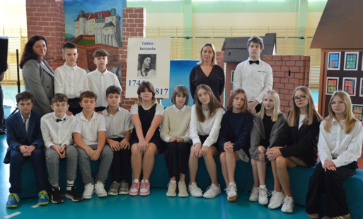 uczniowie stojący oraz siedzący z nauczycielami pozującymi do zdjęcia 